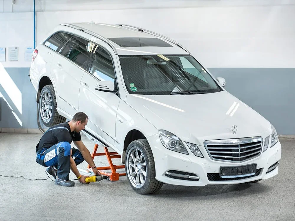 Mechanic operating AUTOLift on station wagon